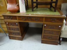 A reproduction writing desk with bank of three upper drawers and pair of flanking drawers and with