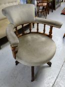 An antique bobbin-back swivel captain's-type chair with upholstered back and seat on spider supports