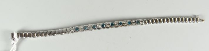A 14k white gold natural and blue diamond (treated) snake chain bracelet set with nine groups of