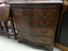 An antique reproduction serpentine chest of four long drawers and with upper brush-slide, 70cms wide