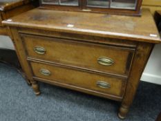 A small two-drawer nineteenth century antique chest of drawers on turned supports and with brass