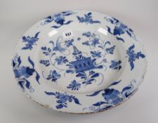 A mid eighteenth century English Delftware charger-dish decorated in naive blue flowers and insects,