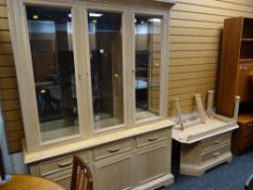A modern limed oak effect three-glass door top cupboard base lounge unit together with a TV stand