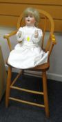 A Schutzmeister & Quendt china doll, model 201 together with a pine child's high chair Condition