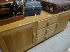 A modern light oak sideboard with three drawers flanked by cupboards Condition reports provided on