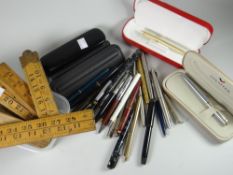 A plastic tub of Sheaffer and other fountain pens and a parcel of vintage wooden folding rulers