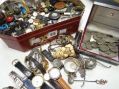 A tin of old buttons, wristwatches, coinage together with wine label, pocket watch ETC Condition