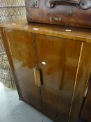 A vintage polished cocktail cabinet with period interior wallpaper and glass interior, 98cms high