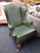 A vintage studded green leather wingback armchair Condition reports provided on request by email for
