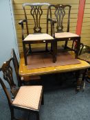 An extending wind out mahogany Edwardian dining table with two leaves and 4+1 Chippendale-type