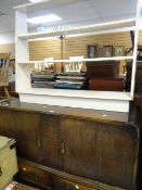 A vintage oak sideboard having two cupboards and two drawers together with an open bookcase