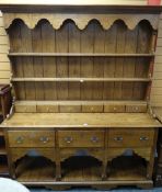 A good reproduction Welsh-type dresser having a planked floor-level platform base, three deep