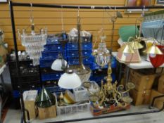 A large collection of lighting, lamps and accessories organised into crates and hanging on a clothes