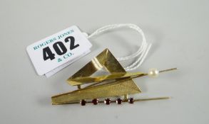 A 9ct yellow gold contemporary abstract brooch set with single pearl and row of red stones / rubies,