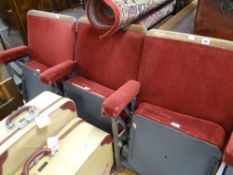 A trio of adjoining vintage numbered red-velvet covered and grey metal folding cinema-seats
