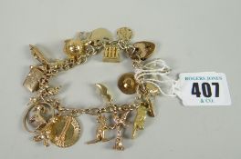 A yellow gold charm bracelet with numerous mainly if not all gold souvenir charms, 49grams total