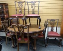 An Edwardian oval extending mahogany dining table on carved ball & claw supports together with three