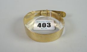 A 9ct yellow gold bangle in the form of a belt with buckle, 10 grams Condition reports provided on