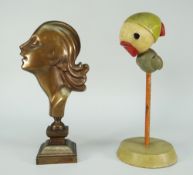 An Art Deco or style polished bronze mask ornament modelled as a lady with long hair over a square