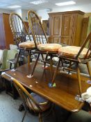 A mid-century Ercol dark wood refectory-type dining table and four matching hoop back chairs