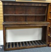 An eighteenth century mixed wood Welsh dairy dresser of simple plank form on tapered supports with