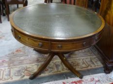 A REPRODUCTION REGENCY STYLE LIBRARY TABLE, the 111.5 cms diameter top with gilt tooled green