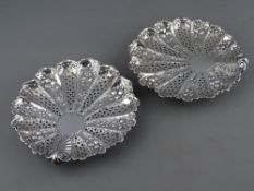 A PAIR OF FINE SILVER SHALLOW DISHES with all over pierced floral and berry decoration, all on three