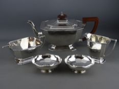 A FIVE PIECE SILVER TEA SERVICE, the teapot, sugar basin and cream jug of oblong form to a stepped
