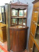 A VICTORIAN MAHOGANY BOW FRONT STANDING CORNER CUPBOARD with mirrored top structure and curved shelf