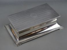 A SILVER ARTHUR & JOHN ZIMMERMAN RECTANGULAR LIDDED BOX, sarcophagus formed base on stepped corner