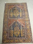 AN OLD BALUCHI RUG, red and blue ground with tonal browns, mirrored central pattern with a triple