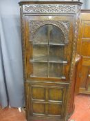 A GOOD FLOORSTANDING REPRODUCTION OAK CORNER CABINET in the antique style, well coloured with carved