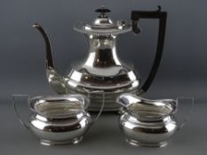 A HANDSOME SILVER COFFEE POT with long spout, narrow neck, four ball supports and composition handle