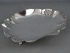 AN OVAL SILVER SHALLOW DISH with wavy border having four small latticed panels and on four pad