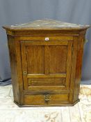 AN ANTIQUE OAK CORNER CUPBOARD, wall hanging with panel front door and lower drawer, 92.5 cms