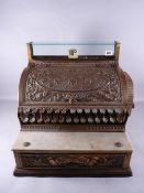 A VICTORIAN NATIONAL CASH REGISTER COMPANY DECORATIVE BRONZE TILL, set up for pre-decimal British