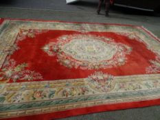 A WASHED CHINESE CARPET, red ground with floral pattern, 3.3 x 5.3 metres