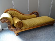 A WELL CARVED VICTORIAN CHAISE LONGUE having fruit and vine detail on substantial bun feet, 81.5 cms