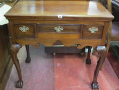 A REPRODUCTION THREE DRAWER LOWBOY on cabriole shell supports with ball and claw feet