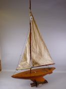 A SCRATCH BUILT POND YACHT, fully rigged with moveable rudder and weighted keel, having titled
