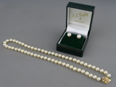 A SINGLE STRAND CULTURED PEARL NECKLACE with nine carat gold clasp together with a pair of