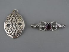 AN OVAL SILVER CELTIC STYLE PENDANT, 4 cms long, 7 grms and a white metal thistle brooch with oval