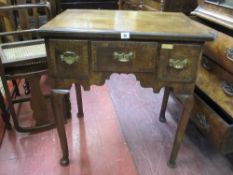 A GEORGE III WALNUT LOWBOY having a quarter cut veneered and crossbanded top over three