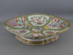 A 19th CENTURY CHINESE CANTON PORCELAIN PEDESTAL DISH, Famille Rose decorated with bordered panels
