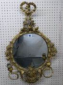 A GILT DECORATED 19th CENTURY CIRCULAR WALL MIRROR with ribbon swag and floral decoration and curled