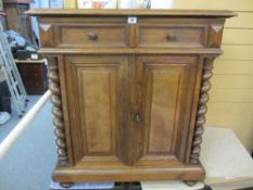 A CONTINENTAL OAK SIDE CUPBOARD having two upper drawers and two lower cupboard doors flanked by