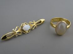 AN EIGHTEEN CARAT GOLD RING with agate cabochon setting and an opal set nine carat gold bar