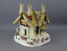 AN UNUSUAL PASTILLE BURNER in the form of a triple chimney floral bedecked cottage lid, on a two