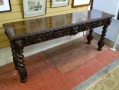 A GOOD CARVED OAK TWO DRAWER HALL TABLE, the 183 cms long top with edge detail over deep carved