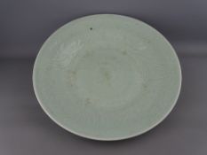 A LARGE GREEN CELADON DISHED CHARGER PLATE, 37 cms diameter